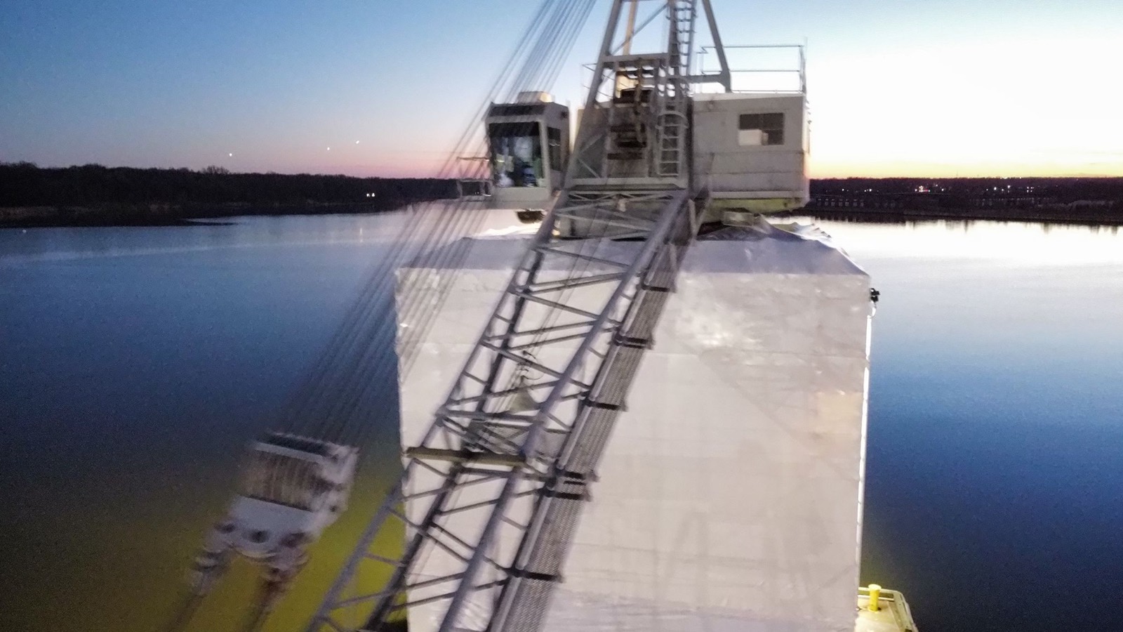 Crane barge at the U.S. Coast Guard Yard in Baltimore fully enclosed in white Titanium Tarps containment